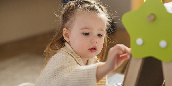 Menina com a mão em brinquedo no Colégio João Paulo I que reconhece a curiosidade infantil para um futuro brilhante. 